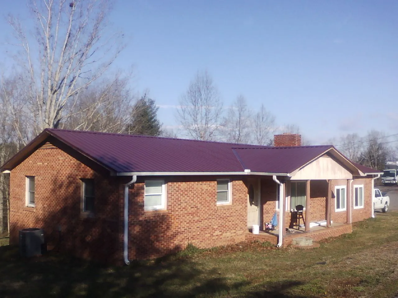 Burgundy metal roof on a brick ranch home with a new addition in Sellersville