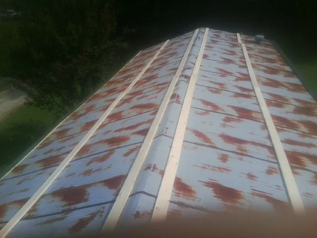 Rusted metal roof panels with new wood purlins before replacement — Storm Damage Roof Repair in Sellersville by Roofing Brothers