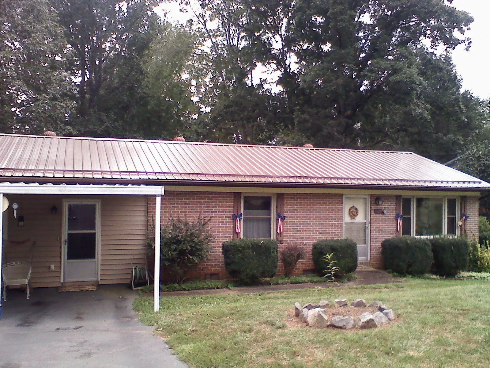 Bronze metal roof and carport on a brick ranch home — Roof Repair work by our crew in Sellersville